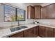 Bright kitchen showcasing wood cabinets, granite countertops, stainless sink, and a window for natural light at 9556 W Frank Ave, Peoria, AZ 85382