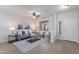 Comfortable living room featuring wood flooring, a contemporary sofa, and large windows for ample natural light at 9556 W Frank Ave, Peoria, AZ 85382