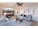 Open-concept living room featuring wood-look tile floors, comfortable seating, and view of the dining room at 9556 W Frank Ave, Peoria, AZ 85382