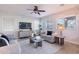 Cozy living room featuring wood-look floors, comfortable seating, a ceiling fan, and natural light at 9556 W Frank Ave, Peoria, AZ 85382