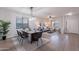 Inviting living room with wood-look tile floors, dining area, and comfortable furniture at 9556 W Frank Ave, Peoria, AZ 85382