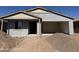 New construction home with a two-car garage and covered porch ready for customization at 9618 W Parkway Dr, Tolleson, AZ 85353