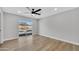 Bright bedroom with wood floors, ceiling fan, and natural light overlooking the pool area at 10013 N 56Th Dr, Glendale, AZ 85302