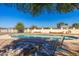 Relaxing poolside view with seating and a fire pit, framed by mature trees at 10212 S 47Th Ave, Laveen, AZ 85339