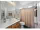 Well-lit bathroom with a wood vanity, shower and neutral-colored shower curtain at 104 W Windsong Dr, Phoenix, AZ 85045