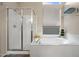 Modern bathroom featuring a walk-in shower and a soaking tub, creating a spa-like experience with ample natural light at 104 W Windsong Dr, Phoenix, AZ 85045