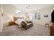 Bright bedroom featuring a comfortable bed, cozy loveseat, and a large window, creating a serene and inviting space at 104 W Windsong Dr, Phoenix, AZ 85045