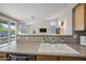 Kitchen with modern sink, wood cabinetry, open layout with views to the Gathering room and backyard patio at 104 W Windsong Dr, Phoenix, AZ 85045