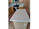 Kitchen island featuring white quartz countertop with view of stainless steel appliances and light wood cabinetry at 104 W Windsong Dr, Phoenix, AZ 85045