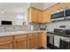 Well-lit kitchen features wood cabinets, stainless steel microwave and oven, and a charming coffee bar setup at 104 W Windsong Dr, Phoenix, AZ 85045
