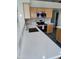 Close-up of the kitchen sink, stainless steel appliances, and white countertops at 104 W Windsong Dr, Phoenix, AZ 85045