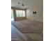 Spacious living room with neutral carpet, large windows allowing ample light and sliding glass door to the backyard at 104 W Windsong Dr, Phoenix, AZ 85045