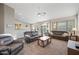 Spacious living area with plush sofas, ceiling fan, and view to kitchen and outdoor pool at 104 W Windsong Dr, Phoenix, AZ 85045
