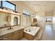Elegant bathroom featuring a soaking tub, double vanity, and natural lighting at 12870 E Rosewood Dr, Scottsdale, AZ 85255