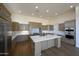 Modern kitchen with a central island, stainless steel appliances, and a view to the dining area at 12870 E Rosewood Dr, Scottsdale, AZ 85255