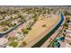 Aerial view of residential area along a canal, showcasing backyard pools and open space at 1310 S Vine Ct, Gilbert, AZ 85233