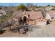 Aerial view of a well-maintained home with a tile roof, three-car garage, and desert landscaping at 1310 S Vine Ct, Gilbert, AZ 85233