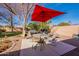 Relaxing backyard featuring a patio with seating and a red umbrella, perfect for outdoor enjoyment at 1310 S Vine Ct, Gilbert, AZ 85233