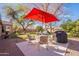 Relaxing backyard featuring a patio with seating and a red umbrella, perfect for outdoor enjoyment at 1310 S Vine Ct, Gilbert, AZ 85233