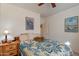 Comfortable bedroom featuring a queen-sized bed with a decorative blue patterned coverlet and wood nightstand at 1310 S Vine Ct, Gilbert, AZ 85233