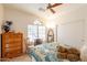 Cozy bedroom with a full-size bed, dresser, and window providing natural light at 1310 S Vine Ct, Gilbert, AZ 85233