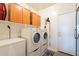 Functional laundry room with washer, dryer, ample cabinet storage, and a door leading to the exterior at 1310 S Vine Ct, Gilbert, AZ 85233