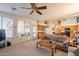 Bright living room that transitions to kitchen, featuring a ceiling fan and ample natural light at 1310 S Vine Ct, Gilbert, AZ 85233