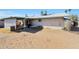 View of the backyard featuring a covered patio, sand yard, and the home's exterior at 14637 N 36Th Dr, Phoenix, AZ 85053