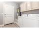 Bright laundry room with washer, dryer, and ample storage cabinets at 1600 W Ivar Rd, San Tan Valley, AZ 85144