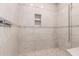 Modern tiled shower with pebble floor, decorative accents, and built in shower niche for added storage at 1600 W Ivar Rd, San Tan Valley, AZ 85144