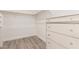 Bright walk-in closet features wood look floors, white walls, and custom storage solutions at 1600 W Ivar Rd, San Tan Valley, AZ 85144
