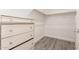 Walk-in closet with wood look floors, white walls, and a built-in dresser for storage at 1600 W Ivar Rd, San Tan Valley, AZ 85144