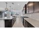 Well-lit kitchen with granite countertops, dark cabinets, and stainless steel appliances, perfect for cooking and entertaining at 17685 W Southgate Ave, Goodyear, AZ 85338