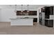 Spacious kitchen featuring dark cabinetry, a large island, and modern stainless steel appliances at 17685 W Southgate Ave, Goodyear, AZ 85338