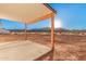 Covered back patio featuring wooden posts, a concrete slab, and scenic mountain views at 17940 N Luke Ln, Maricopa, AZ 85139