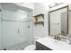 This bright bathroom features a glass-enclosed shower, floating wood shelves, and a vanity with a large mirror at 2106 W Shawnee Dr, Chandler, AZ 85224