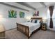 Bright bedroom with a wooden bed frame, colorful artwork, and cozy decor at 2106 W Shawnee Dr, Chandler, AZ 85224