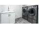 Well-equipped laundry room featuring modern washer and dryer units alongside a utility sink and cabinet at 2106 W Shawnee Dr, Chandler, AZ 85224