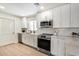 Well-lit kitchen with modern white cabinets, stainless steel appliances, and hardwood flooring at 2126 N 69Th Pl, Scottsdale, AZ 85257