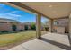 Covered patio with spacious concrete and lush green grass, providing an inviting outdoor space at 22443 E Munoz St, Queen Creek, AZ 85142