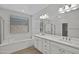 Bright bathroom featuring a dual sink vanity, separate tub, and glass enclosed shower at 22443 E Munoz St, Queen Creek, AZ 85142