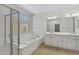 Bathroom featuring a separate glass shower, soaking tub, and dual sink vanity at 22443 E Munoz St, Queen Creek, AZ 85142