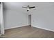 Bright, spacious bedroom with wood floors, a ceiling fan, and a glimpse of another room at 22443 E Munoz St, Queen Creek, AZ 85142