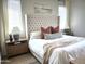 Bright bedroom featuring a tufted headboard, neutral bedding, and natural light from the windows at 22443 E Munoz St, Queen Creek, AZ 85142
