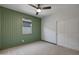 Stylish bedroom with wainscoting, a window with woven shades, and a modern ceiling fan at 22443 E Munoz St, Queen Creek, AZ 85142