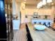 Bright dining space featuring a rustic table beneath a modern chandelier, adjoining a kitchen with white cabinetry at 22443 E Munoz St, Queen Creek, AZ 85142