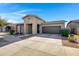 Attractive single-story home with a covered entryway, two-car garage, and well-maintained landscaping at 22443 E Munoz St, Queen Creek, AZ 85142