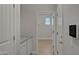 Hallway featuring wood-look floors and a view into another room with a window at 22443 E Munoz St, Queen Creek, AZ 85142