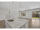 Open-concept kitchen overlooking the living area with white cabinets and a large kitchen island at 22443 E Munoz St, Queen Creek, AZ 85142