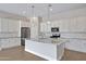 Bright kitchen with a large island, granite counters, stainless appliances, and white cabinets at 22443 E Munoz St, Queen Creek, AZ 85142